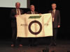 TAC2010 Chair Dean Brox (Left) receiving ITA Flag from ITA President Martin Knights (Center) and Budapest 2009 Chair Pal Kocsonya (Right)